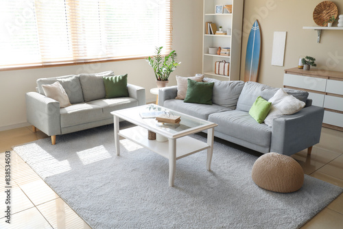 Wallpaper Mural Interior of living room with cozy sofa, table and surfboard Torontodigital.ca