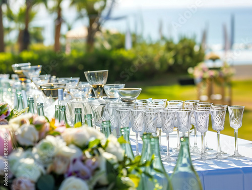 Sfondo di buffet all'aperto ad un matrimonio con bicchieri e bevande eleganti decorati da fiori su prato in luce naturale photo