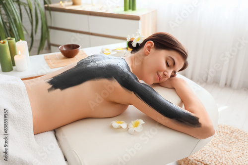 Young woman undergoing mud ...