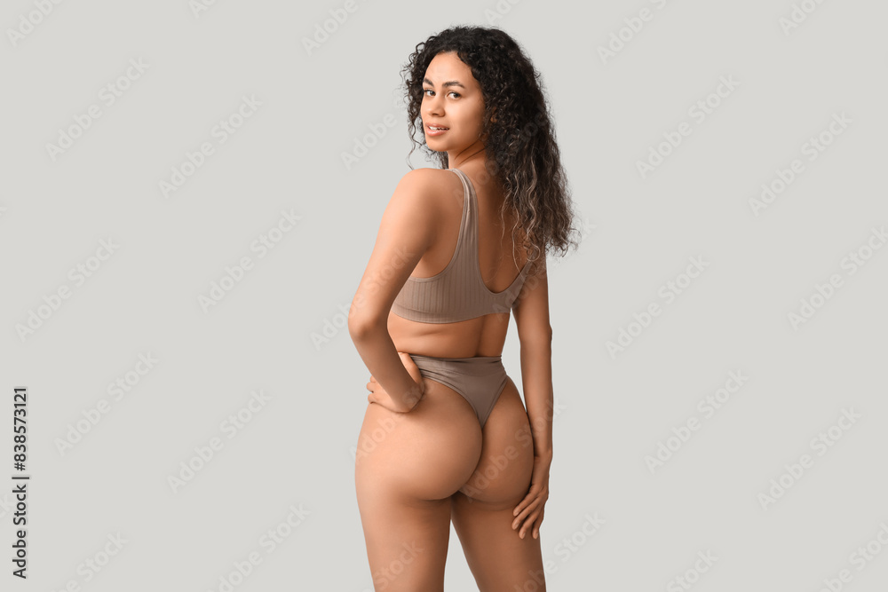 Beautiful young happy African-American woman in stylish underwear on grey background Beautiful young happy African-American woman in stylish underwear on grey background