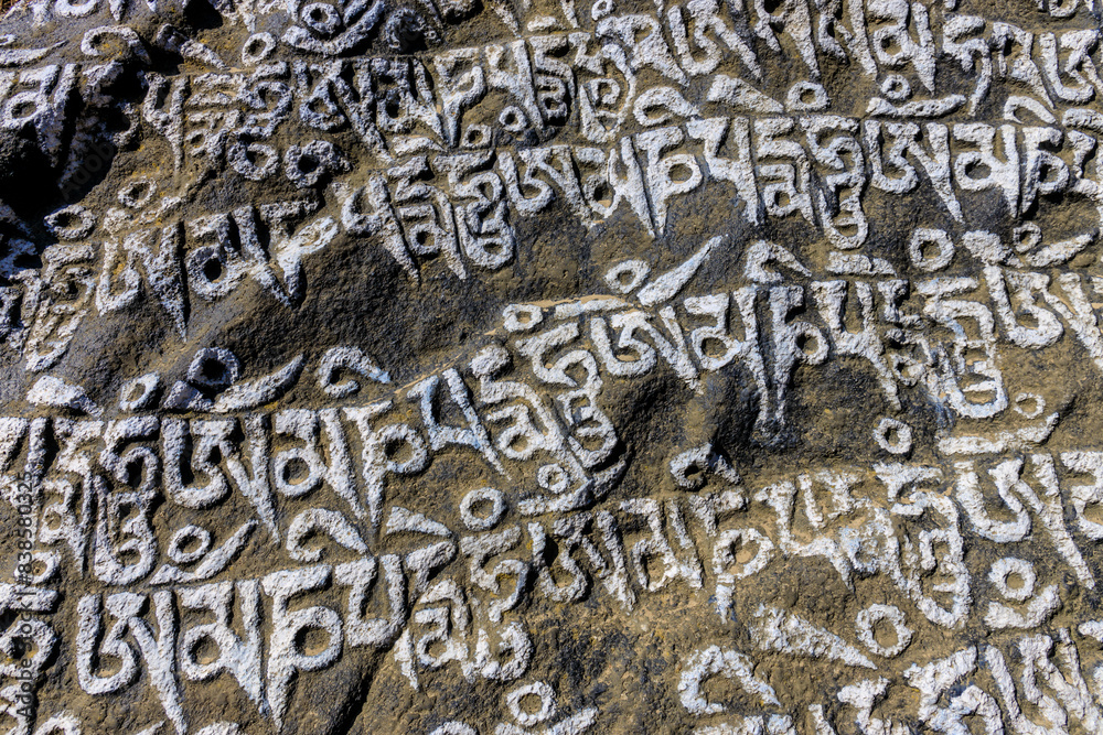 Nepal sacred stones mani with mantra written and carved on the surface. Prayer stones shire on the mountain trekking path on Everest Base Camp trek. Nepali buddhist mantra Om Mani Padme Hum on rock Nepal sacred stones mani with mantra written and carved on the surface. Prayer stones shire on the mountain trekking path on Everest Base Camp trek. Nepali buddhist mantra Om Mani Padme Hum on rock