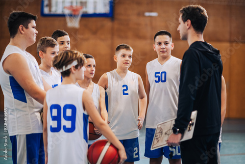 Fotografie A junior basketball team with their coach at indoor court on training