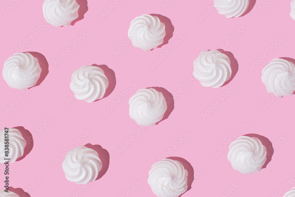 White meringue cookies on a bright pink background. Creative sweet delicacy pattern, dessert background. White meringue cookies on a bright pink background. Creative sweet delicacy pattern, dessert background.
