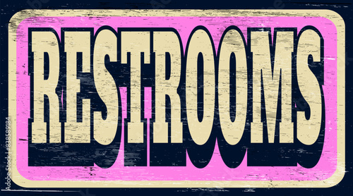 Aged and worn restrooms sign on wood