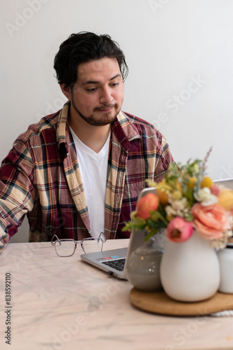 Young man making a video conference and making gestures in the living room