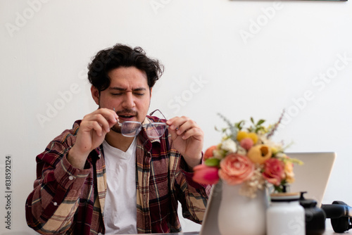 Young man with visual problems tyring to use a glasses to resolve his problem