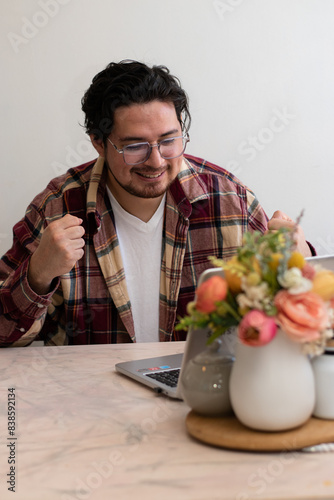 Young man using Glasses for firts time and get emotion gestures front his laptop in the living room photo