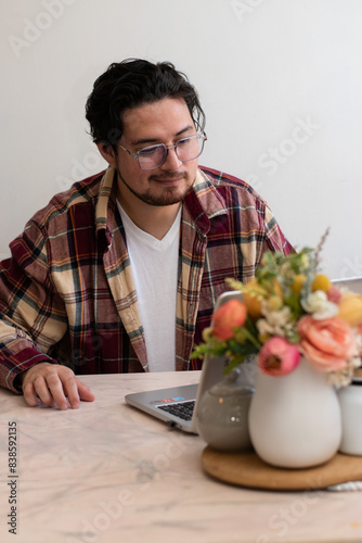 Young man making a video conference and making gestures in the living room