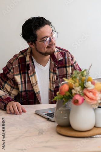 Young man making a video conference and making gestures in the living room