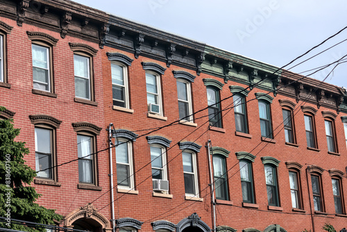 jersey city brownstone building detail (historic pre-war red brick buildings with power lines) beautiful real estate apartment homes with cornice decor urban city life window detail close up family