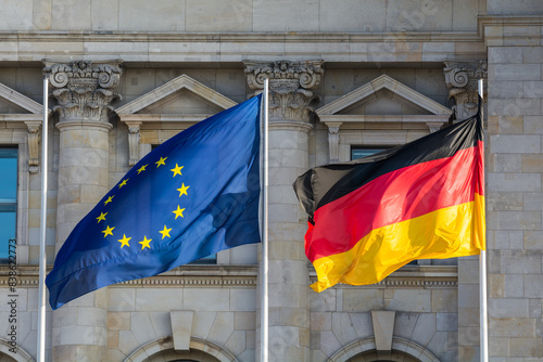 The flags of the European Union and Germany wave in front of the German parliament in Berlin