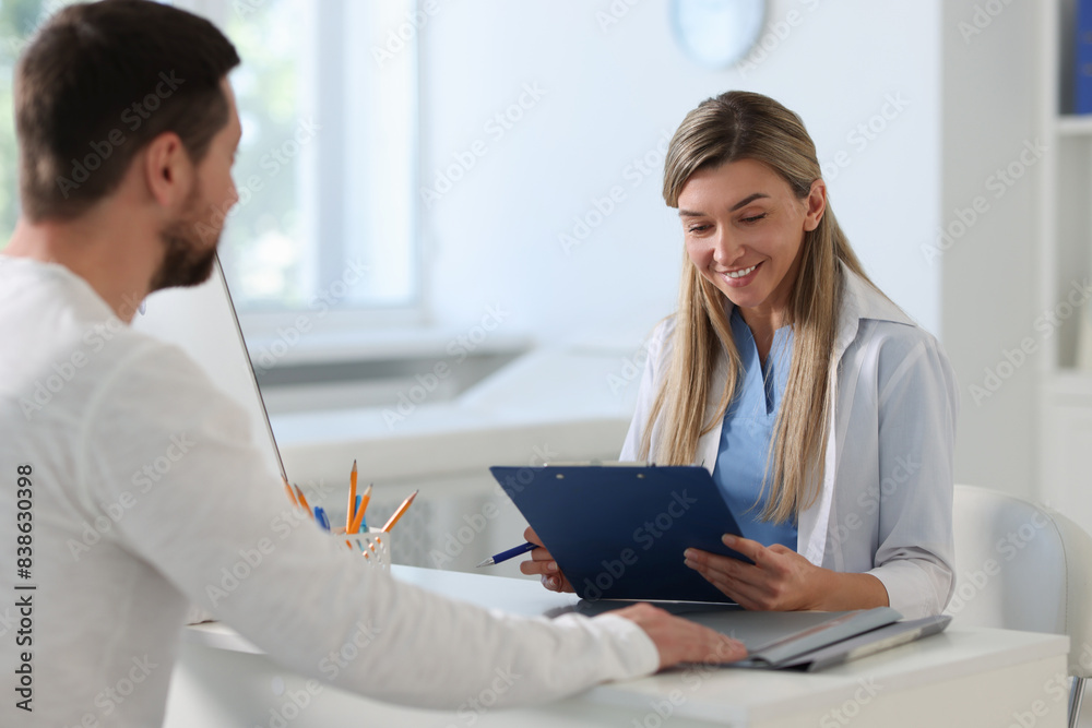 Professional doctor working with patient at white table in hospital Professional doctor working with patient at white table in hospital