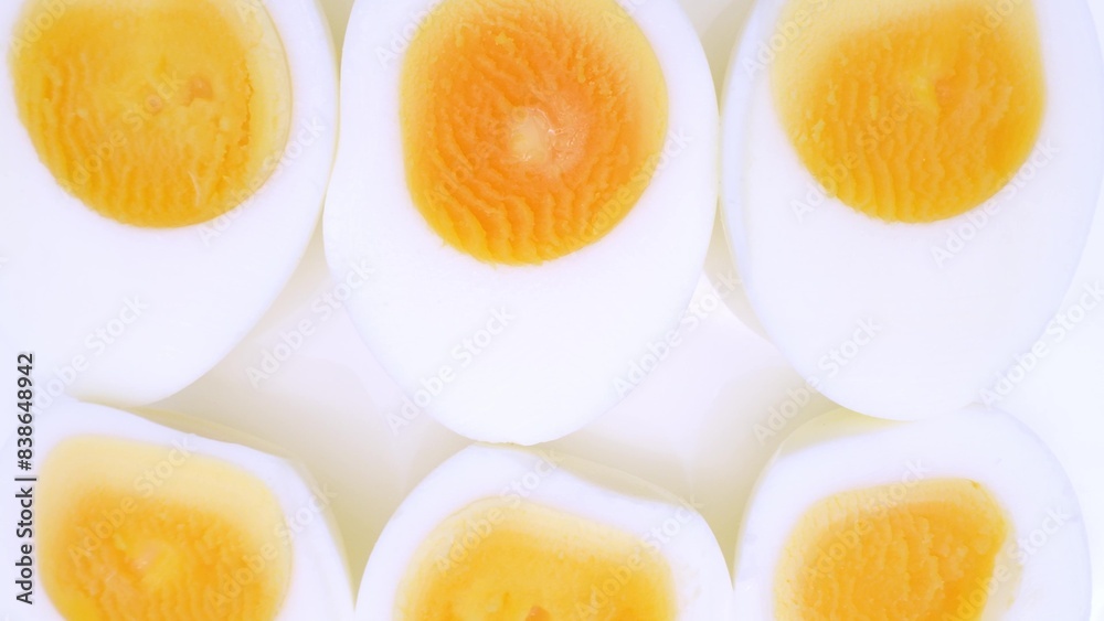 A close-up captures halved boiled eggs, unveiling perfectly cooked yolks cradled by smooth whites. The vibrant yellow against pristine white is both visually striking and nutritionally enticing.
A close-up captures halved boiled eggs, unveiling perfectly cooked yolks cradled by smooth whites. The vibrant yellow against pristine white is both visually striking and nutritionally enticing.