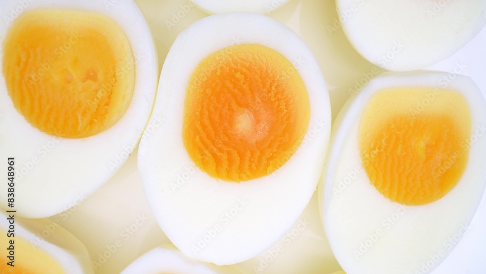 Sliced boiled eggs, each halved, exhibit vibrant yellow yolks encircled by resilient, snow-white egg whites. Their texture suggests firmness, indicative of a perfectly hard-boiled consistency.
Sliced boiled eggs, each halved, exhibit vibrant yellow yolks encircled by resilient, snow-white egg whites. Their texture suggests firmness, indicative of a perfectly hard-boiled consistency.