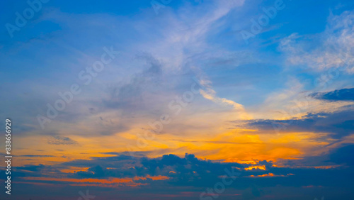 A breathtaking sunrise with a beautiful gradient from deep blue at the top to warm golden hues near the horizon. Dark clouds add contrast  enhancing the vibrant morning colors. Sunrise sky background.