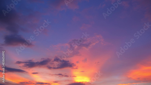 A vibrant sunset with a stunning blend of pink  orange  and purple hues. Dark clouds create a dramatic contrast  while the light rays give the sky a mesmerizing glow. Sunset sky background. 