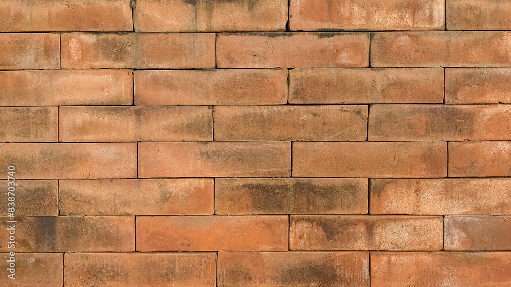 Fototapeta premium Weathered red brick wall texture, close-up shot. Red brick surface with rustic charm
