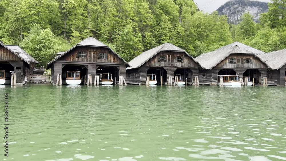 Boat ride passing by the wooden boat sheds at picturesque Lake Königssee near Berchtesgaden in the Bavarian Alps in Germany Boat ride passing by the wooden boat sheds at picturesque Lake Königssee near Berchtesgaden in the Bavarian Alps in Germany