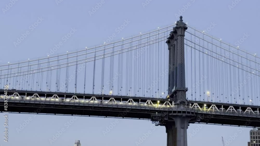 Close-up view of the Manhattan Bridge illuminated at twilight, showcasing the intricate details of its structure and the soft evening light against a clear sky. Close-up view of the Manhattan Bridge illuminated at twilight, showcasing the intricate details of its structure and the soft evening light against a clear sky.