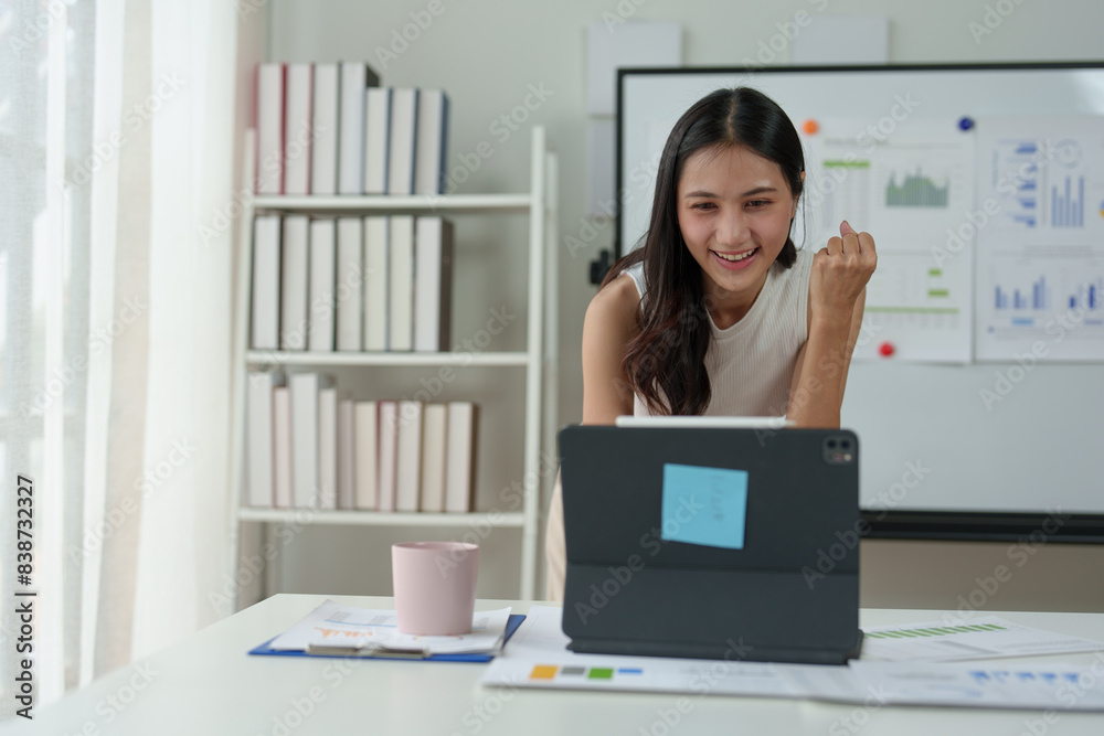 Cheerful Asian woman is delighted to receive results of income, finance, business growth from online on laptop. Excited happy business woman Online success concept. Cheerful Asian woman is delighted to receive results of income, finance, business growth from online on laptop. Excited happy business woman Online success concept.
