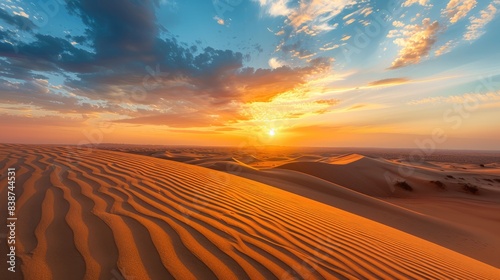 Tranquil and serene scene of a golden hour desert sunset over the vast rolling dunes   