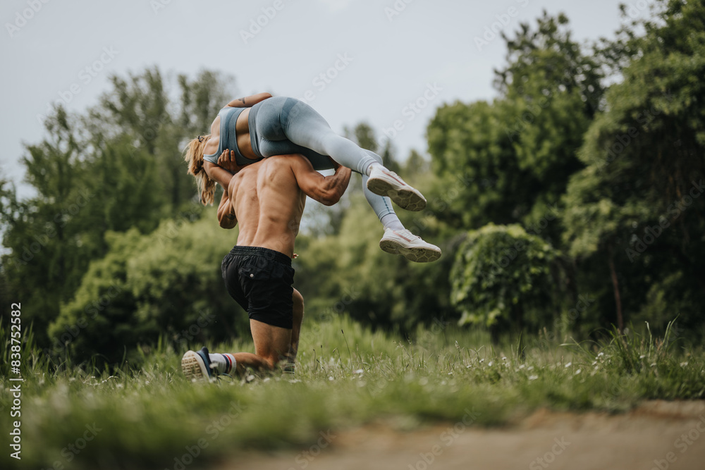 Man carrying his girlfriend on his shoulders in a playful and lively manner in the park, enjoying a sunny day outdoors. Man carrying his girlfriend on his shoulders in a playful and lively manner in the park, enjoying a sunny day outdoors.