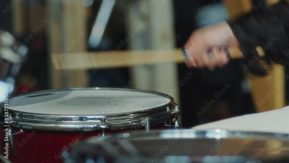 Hands of unrecognizable girl hitting drums with sticks when playing music on drum kit. Close-up view Hands of unrecognizable girl hitting drums with sticks when playing music on drum kit. Close-up view