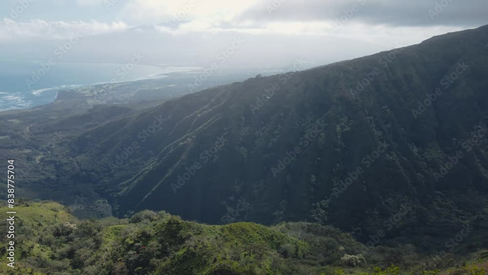 Aerial view flying over lush green misty mountain peaks in Maui, Hawaii Aerial view flying over lush green misty mountain peaks in Maui, Hawaii