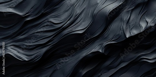 obsidian texture of black and grey marbled fabric on a black background photo