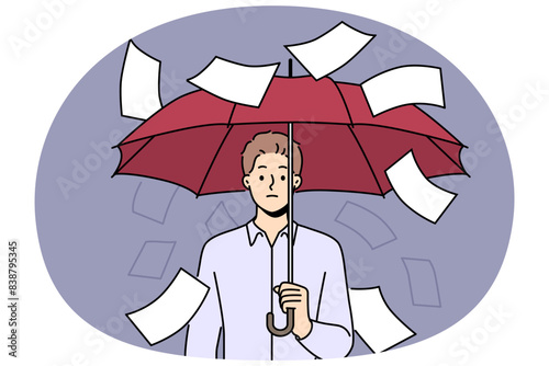 Businessman suffering from bureaucracy standing with umbrella among falling documents symbolizing overabundance of paperwork. Business concept of inefficiency in corporation due to bureaucracy