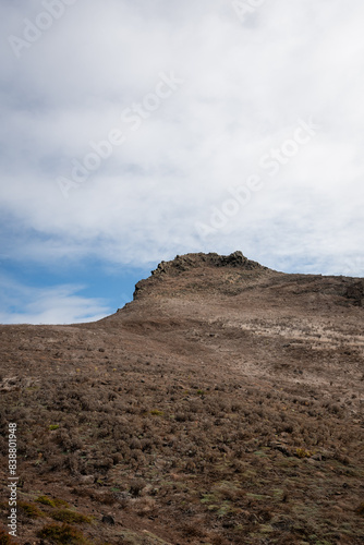 Rocky peak of a mountain against the cloudy sky