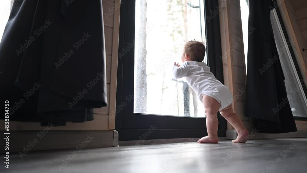 Baby boy standing by the patio window. Baby boy standing by the patio window.