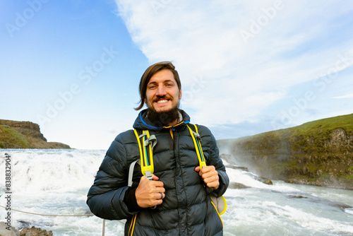 Man tourist in Gullfoss waterfall, in Iceland.