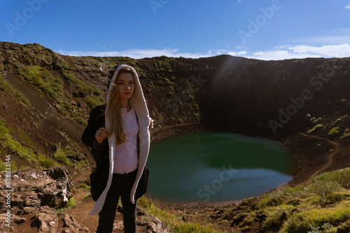 Woman traveler on the slope of Kerid crater lake. photo