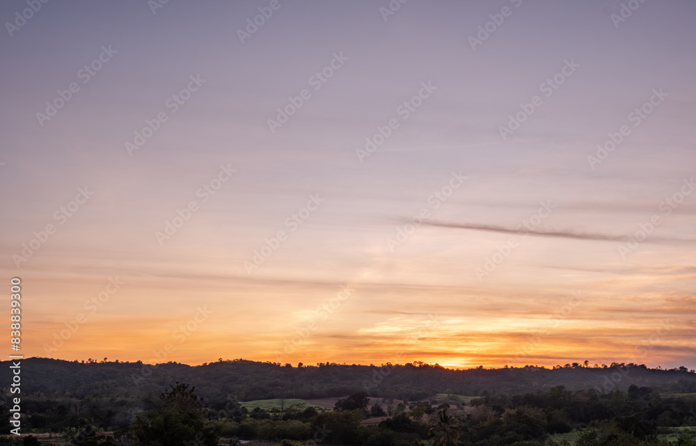 Fototapeta premium Panoramic view of sunset golden and blue sky nature background. Colorful dramatic sky with cloud at sunset.Sky background.Sky with clouds at sunset.