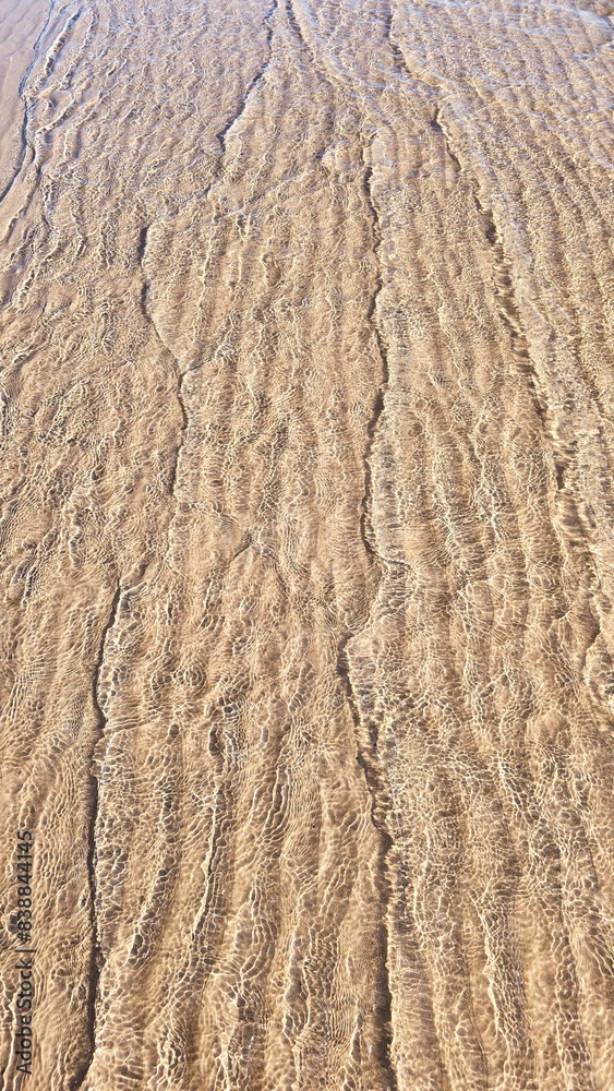 Small waves gently lap the sandy shore in this golden, textured beach pattern. Small waves gently lap the sandy shore in this golden, textured beach pattern.