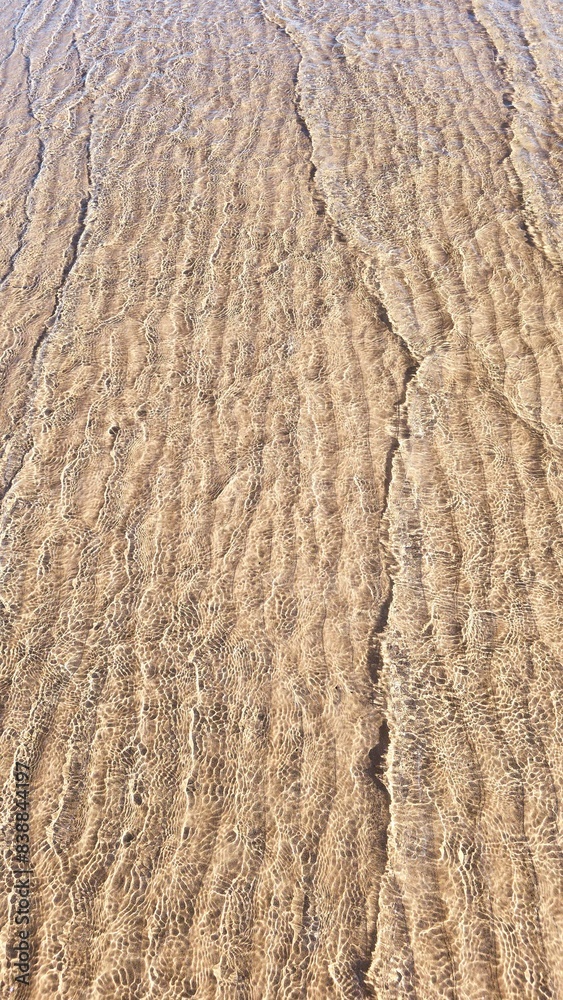 Small waves gently lap the sandy shore in this golden, textured beach pattern. Small waves gently lap the sandy shore in this golden, textured beach pattern.
