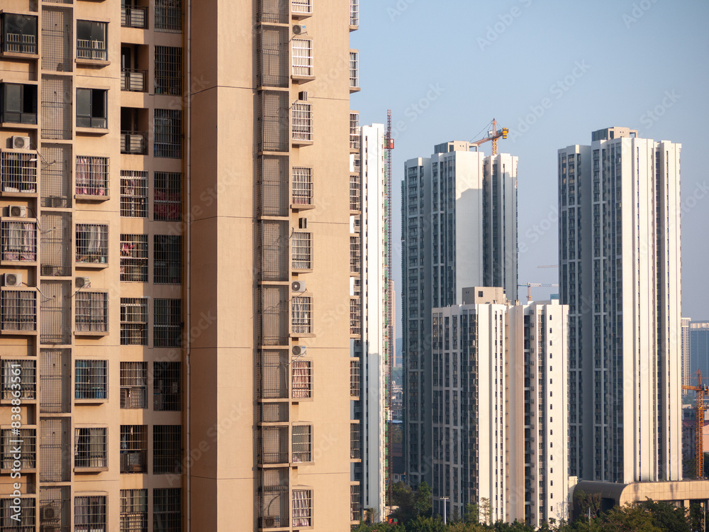 Established high-rise residential apartment buildings with the construction site of even taller, modern residences in the distance. City of Liuzhou, Guangxi, China. Concept of Real estate development Established high-rise residential apartment buildings with the construction site of even taller, modern residences in the distance. City of Liuzhou, Guangxi, China. Concept of Real estate development