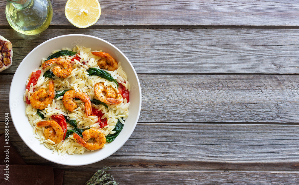 Orzo pasta with shrimp, spinach and tomatoes. Italian Cuisine. Seafood. Orzo pasta with shrimp, spinach and tomatoes. Italian Cuisine. Seafood.