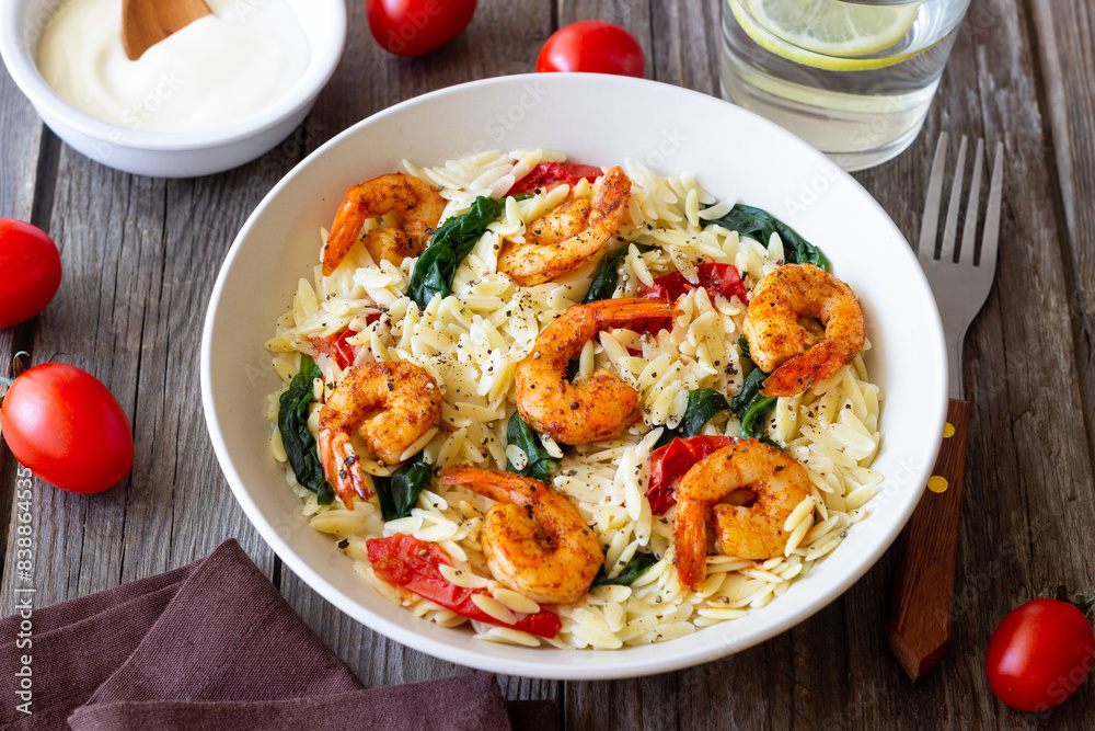 Orzo pasta with shrimp, spinach and tomatoes. Italian Cuisine. Seafood. Orzo pasta with shrimp, spinach and tomatoes. Italian Cuisine. Seafood.