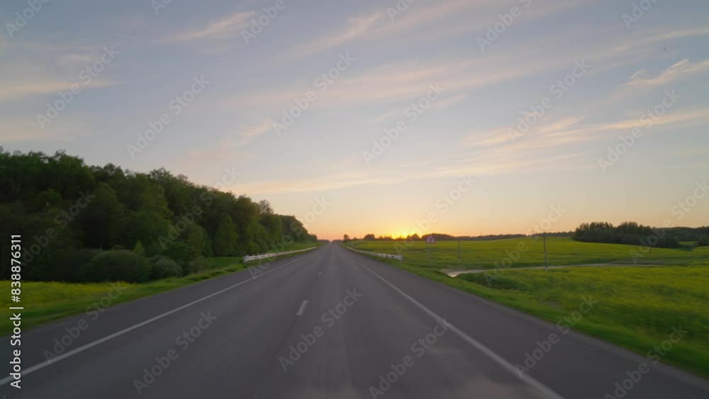 Driving along a country road at sunset Driving along a country road at sunset