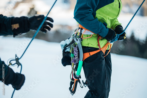Climbers preparing for an ice climb with harnesses and ropes photo