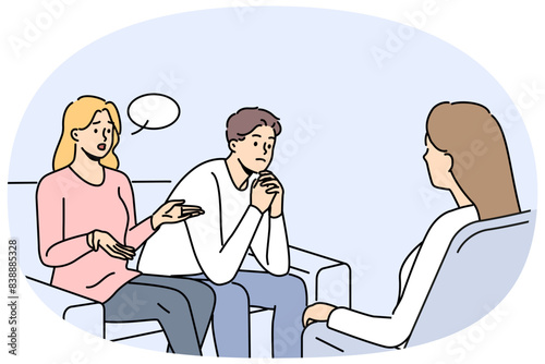 Couple at family therapist in office, sitting on couch talking about problems and quarrels. Woman family therapist helps people get rid of conflicts and misunderstandings in their life together