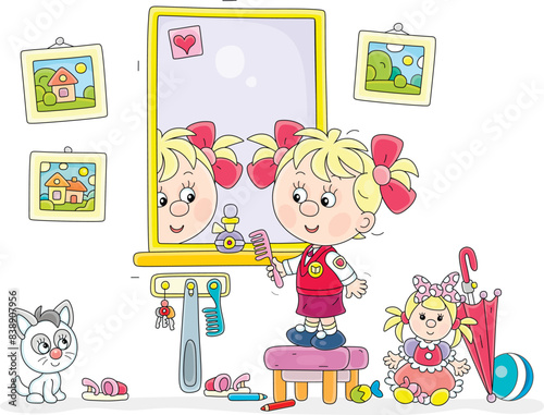 Funny little girl combing her hair in front of a mirror in a hallway with scattered toys and pictures on a wall, vector cartoon illustration isolated on white