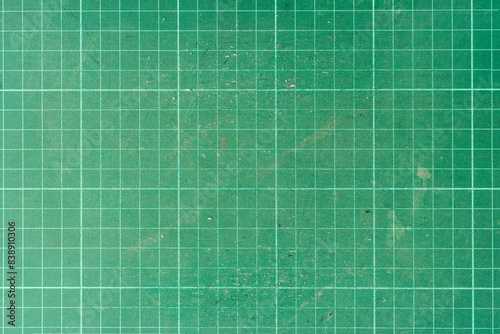 Background and textured of cutting mat green color. Used paper cutting mat.