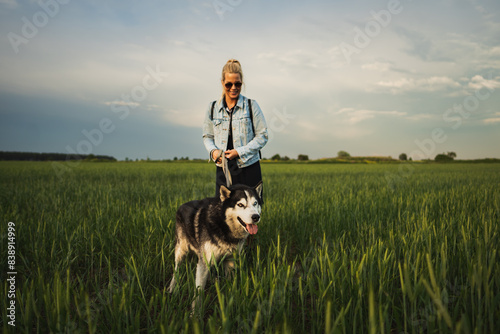 Wallpaper Mural A husky dog ​​with multi-colored eyes on a leash with its owner, a girl, in a field on a summer evening. Torontodigital.ca