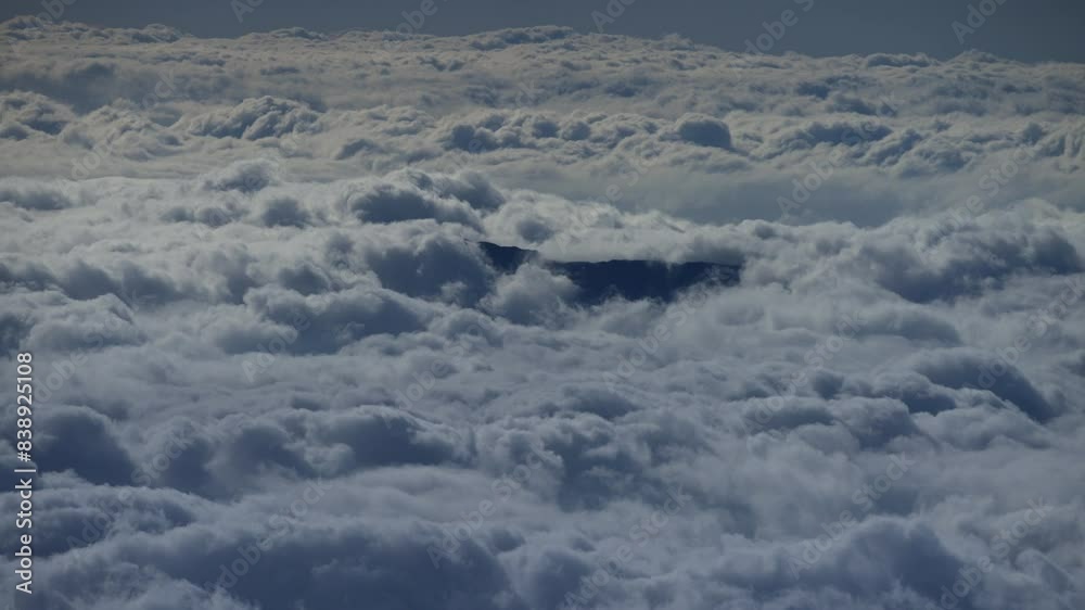 Wide aerial timelapse of fluffy clouds moving by dark mountain top Wide aerial timelapse of fluffy clouds moving by dark mountain top