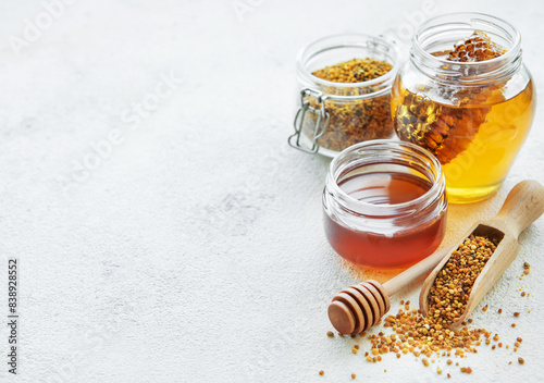 Raw organic bee pollen and honey in jars.