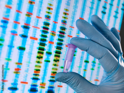 Obraz na płótnie Scientist holding a DNA sample with the results on a computer sceeen in a laboratory w salonie