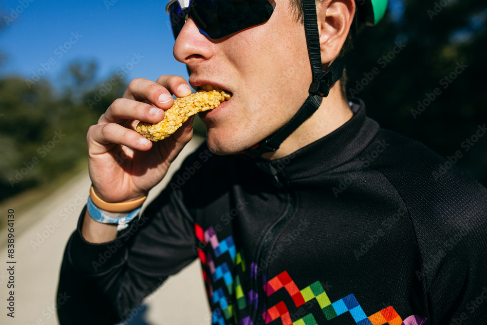 Portrait of cyclist eating a snack during a break on a sunny day